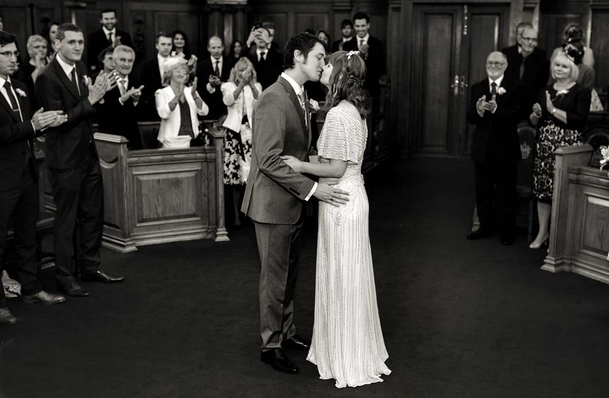 Wedding couple kiss in Islington town hall