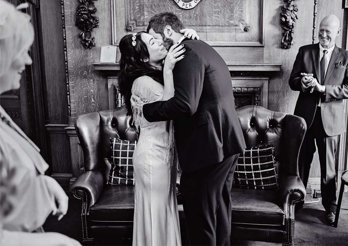 wedding couple hug and kiss at Islington town hall