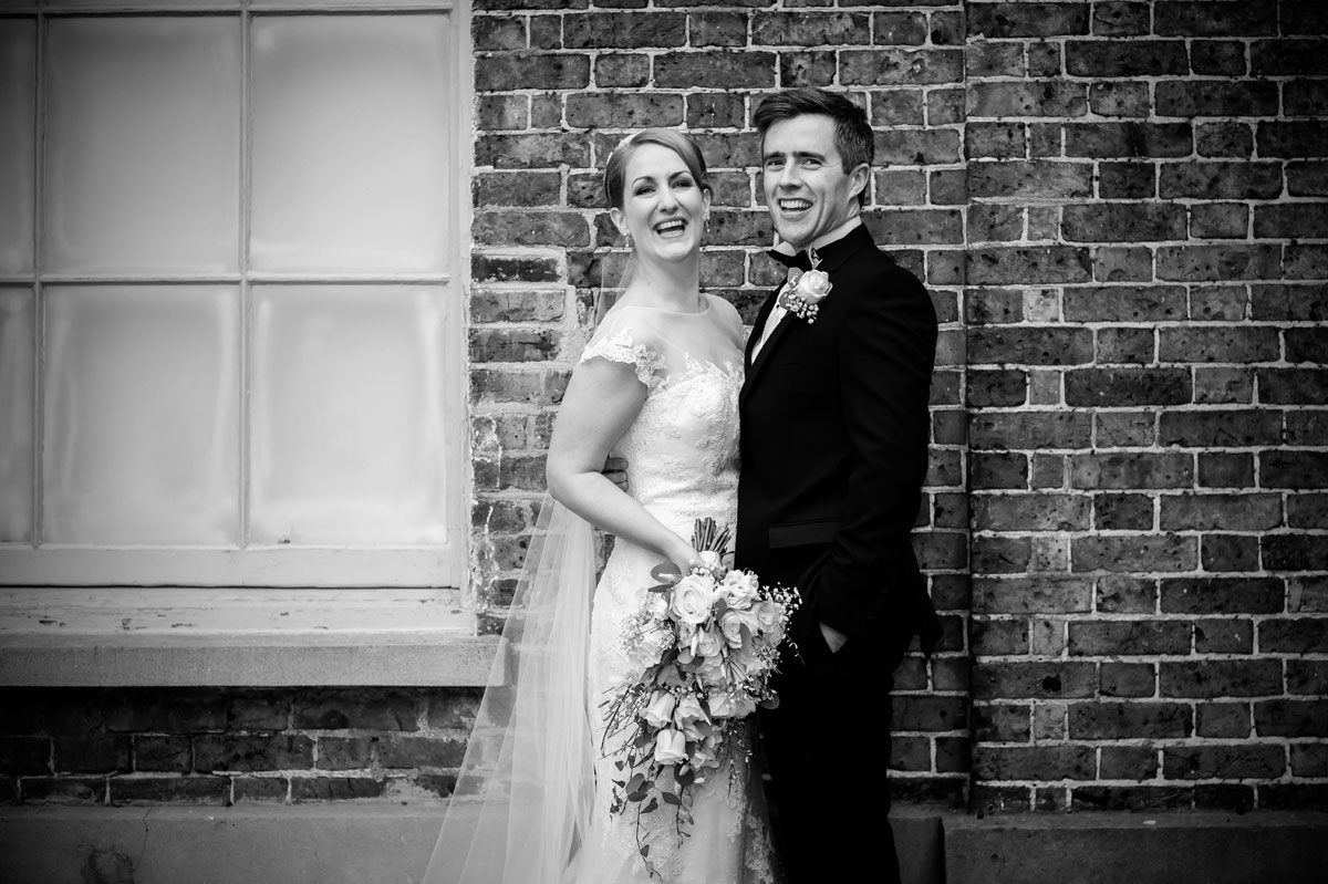 Laughter at Hampton Court wedding black and white image