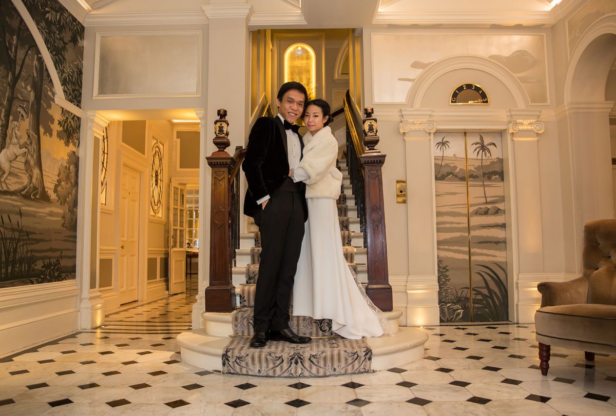wedding couple pose on the stairs at The Goring Hotel
