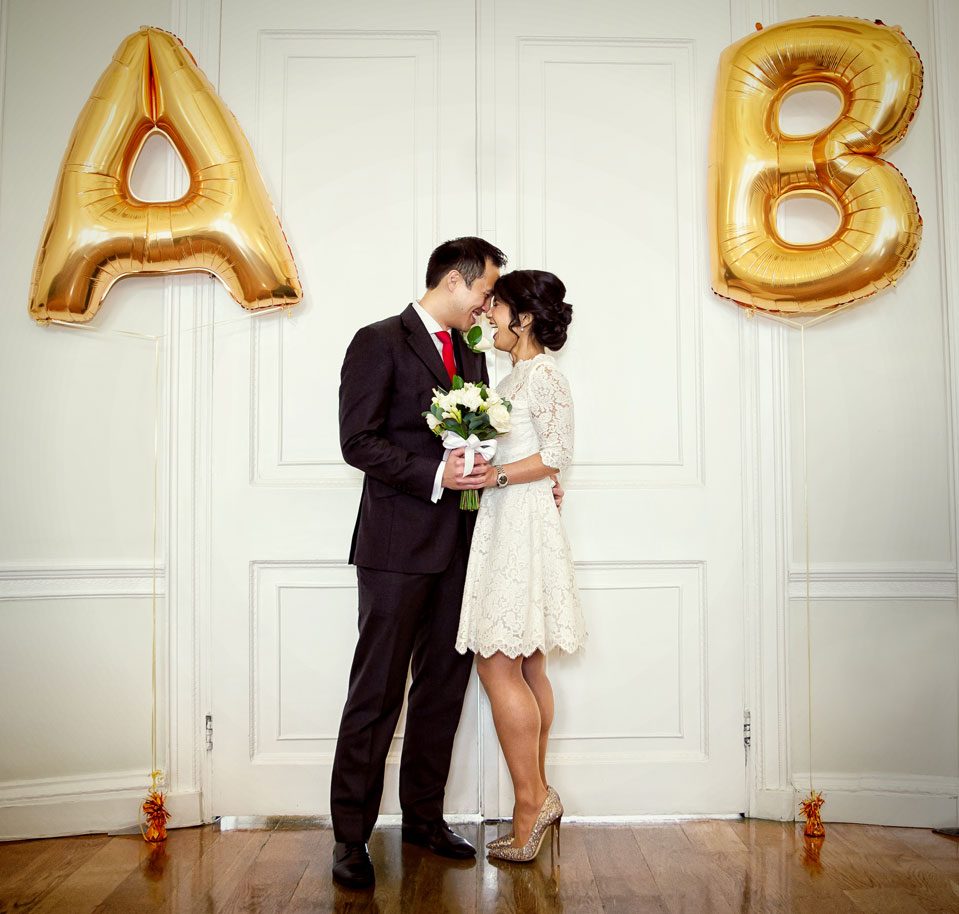 wedding couple laugh inside Asia House with balloons