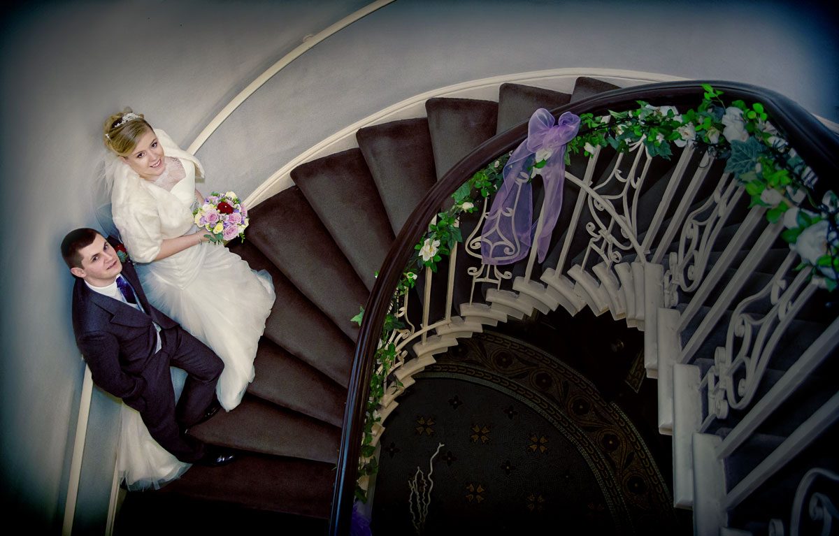 Wedding couple pose on stairs at Theobalds Park
