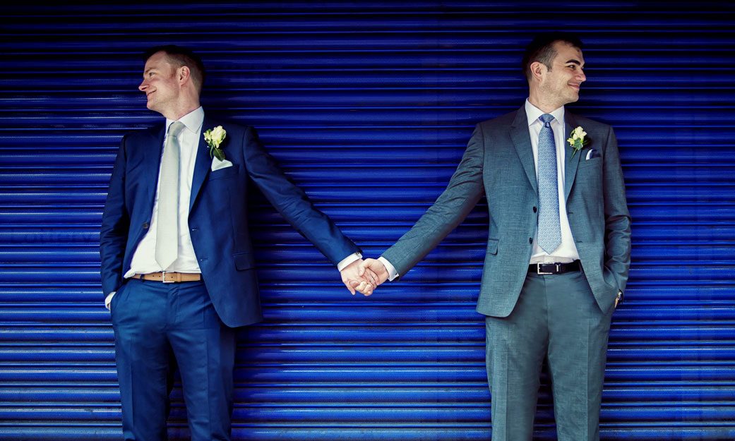 men hold hands on their London wedding day