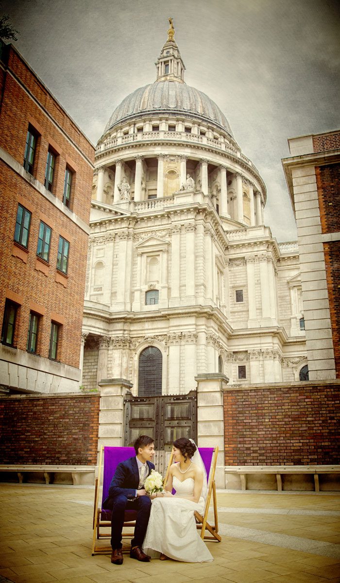 Wedding couple on deckchairs by St Pauls cathedral London