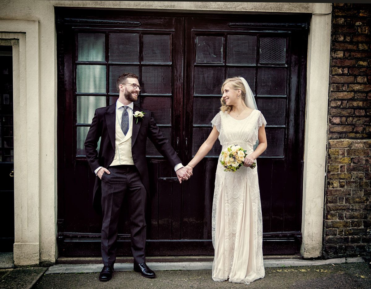 Couple pose by garage doors at Mayfair wedding