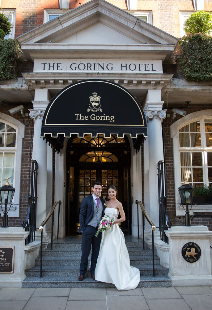 Wedding couple pose outside The Goring Hotel