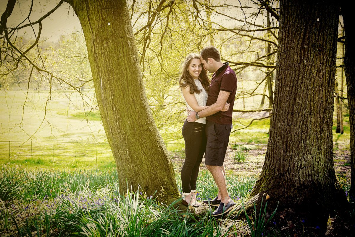 Couple hug by tree during Hampstead and Kemwood engagement photography