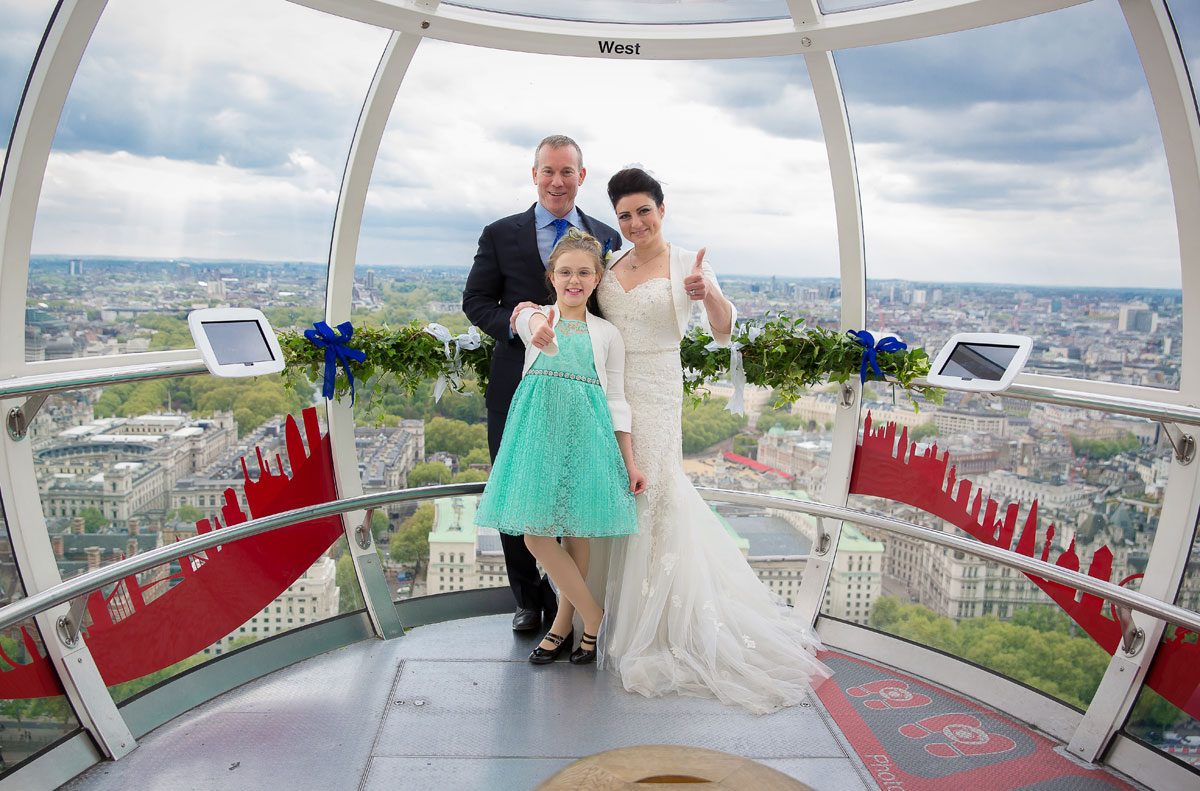 Wedding couple and daughter pose on the London Eye