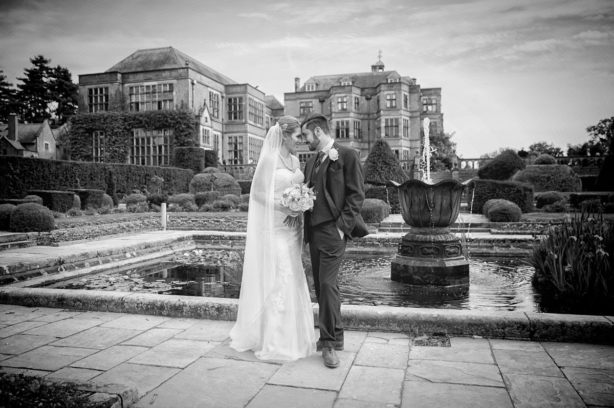 Bride and groom head to head in Fanhams Hall wedding garden in black and white