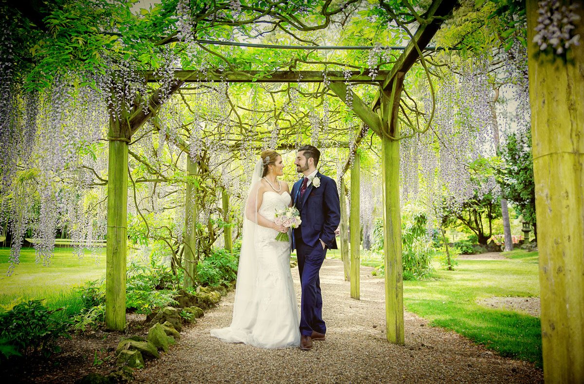 Fanhams Hall wedding bride and groom in wisteria garden image