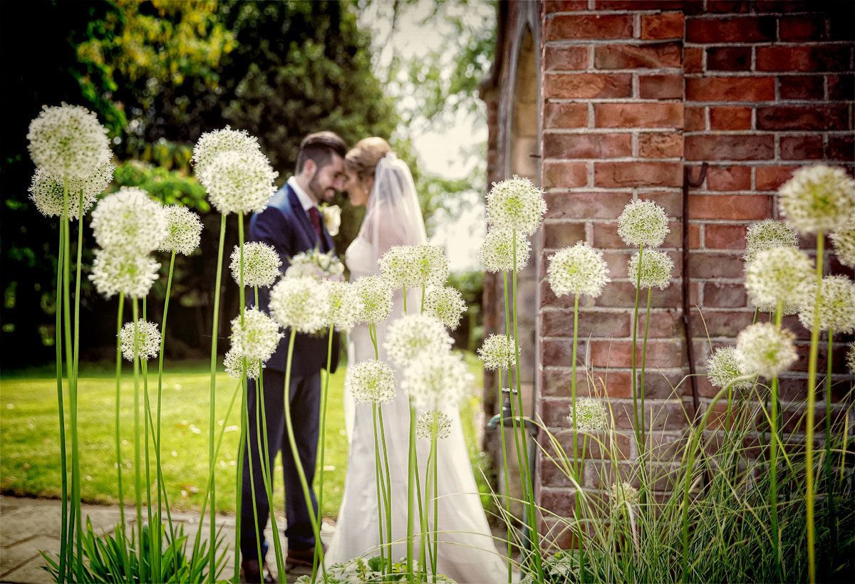 Flowers and wedding couple in grounds of Fanhams Hall