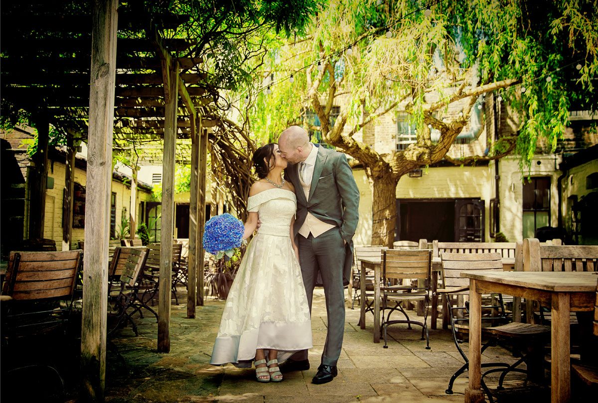 Wedding couple kiss in garden of Albion Pub Islington