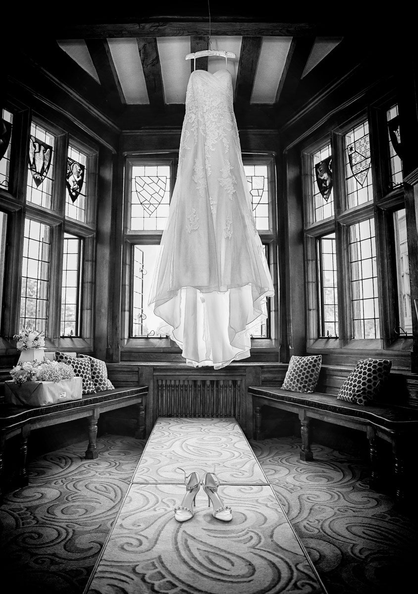 Wedding dress hanging in window at Fanhams Hall photoall