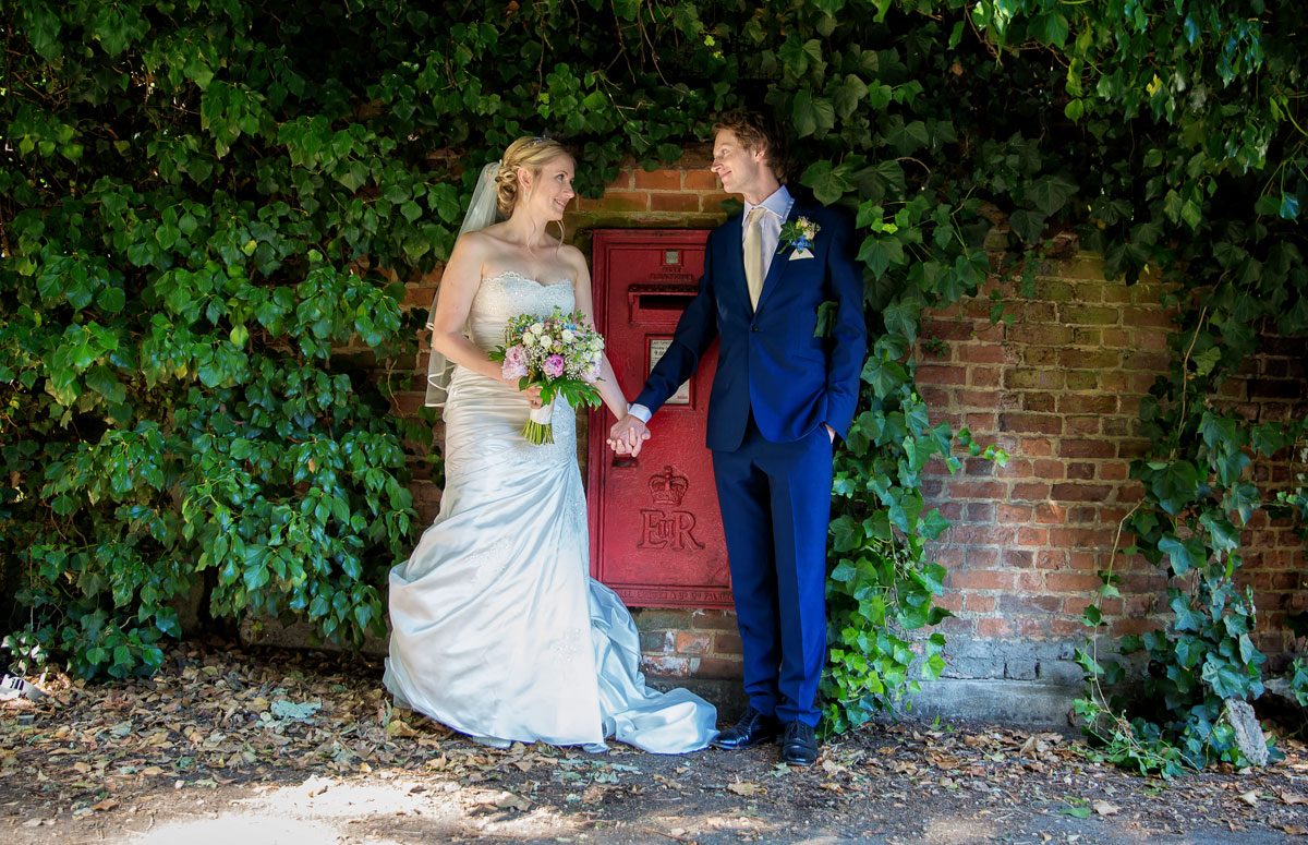 Barnet wedding couple hold hands by red post box