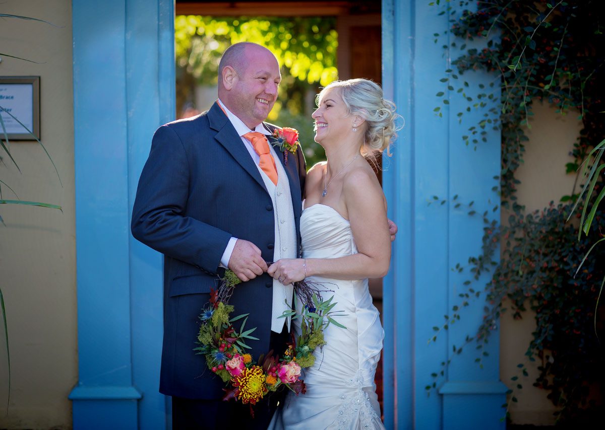 Couple laugh in doorway South Farm wedding