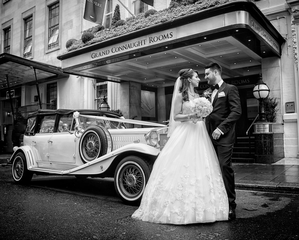 Bride groom and wedding car outside the Grand Connaught Rooms London