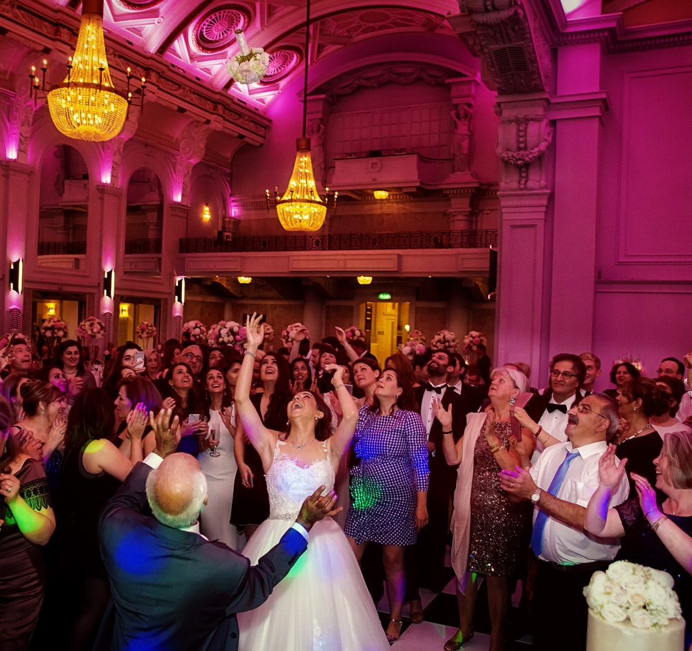 Tossing the bouquet at Connaught Rooms wedding reception