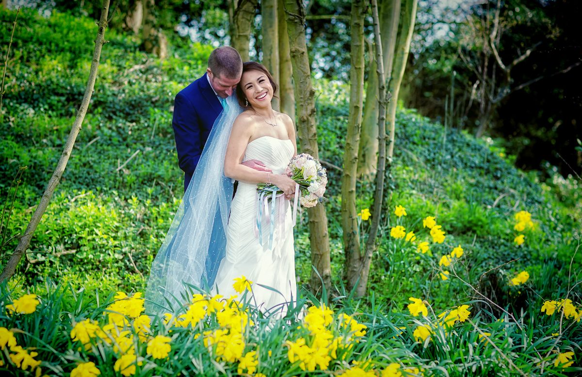 Bride and groom in daffodils at Hanbury Manor Wedding