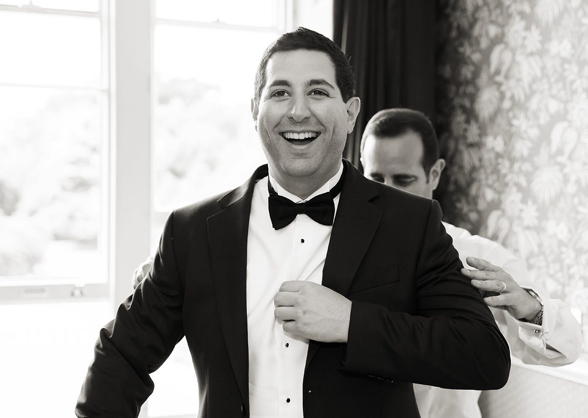 Groom laughs getting ready for Shendish Manor Hotel wedding
