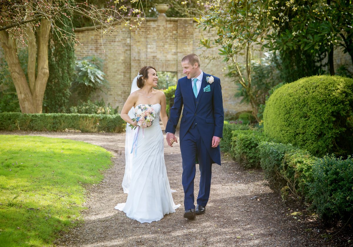 Wedding couple walking in Hanbury Manor walled garden