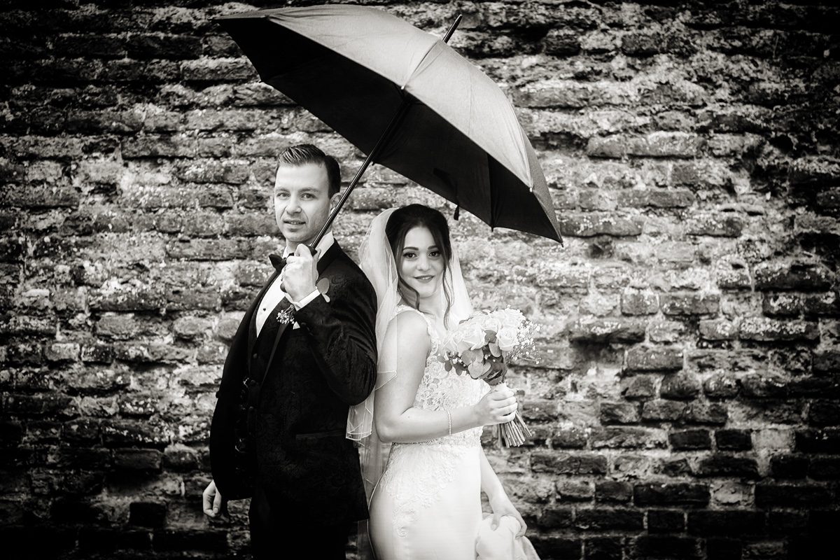 Bride and groom under umbrella after Southgate London wedding