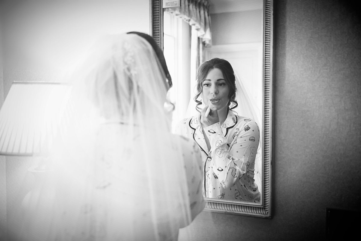 Bride gets ready with mirror West Lodge Park Hotel