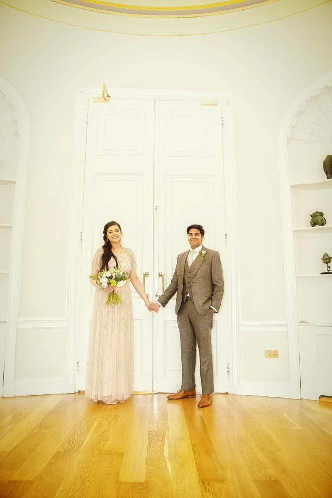 Bride and groom hold hands in Asia House London