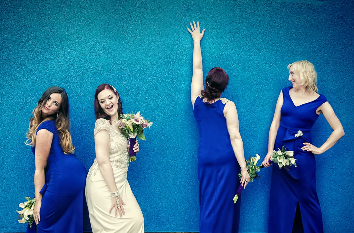Islington wedding brides pose in front of blue wall London