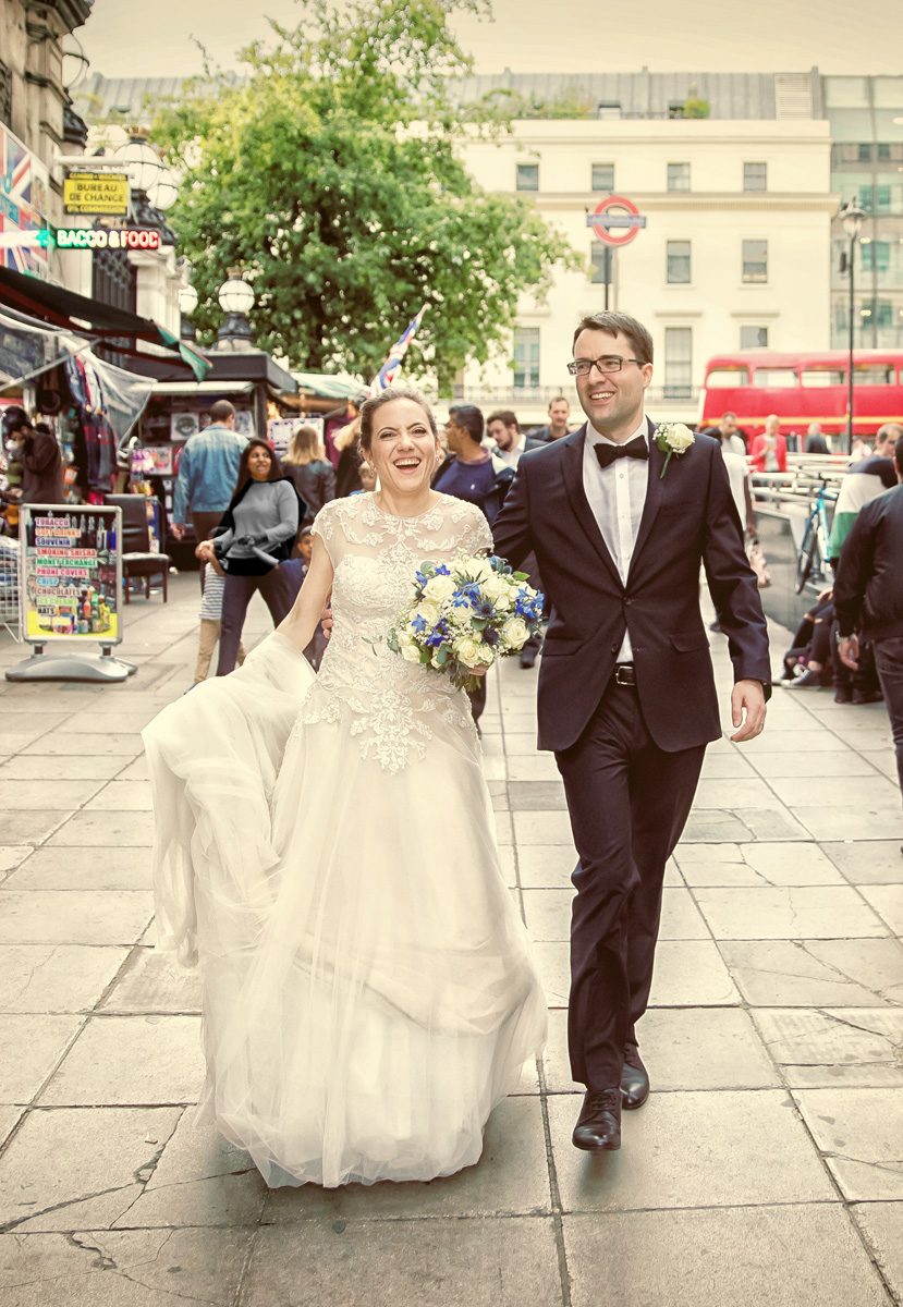 Bride and groom walking through London's Charing Cross area