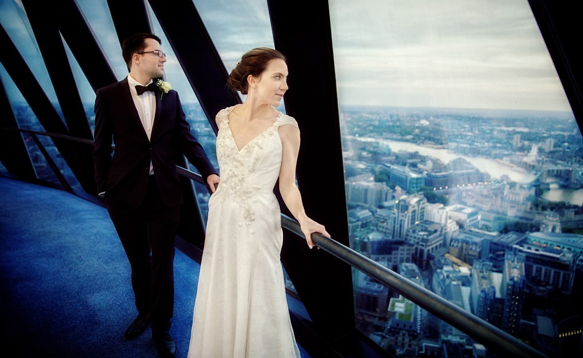 London couple look out of Gherkin window at wedding reception