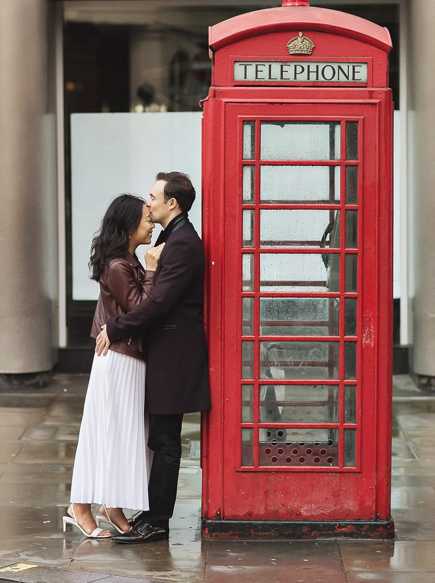Couple kiss by red London phone box engagement shoot image