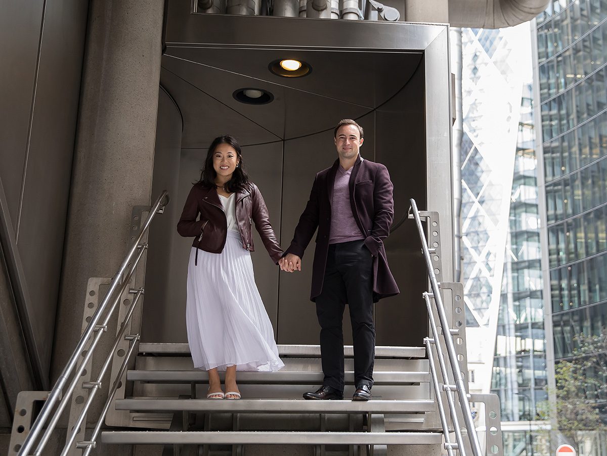 Engagement couple hold hands on steps of Lloyds Building London