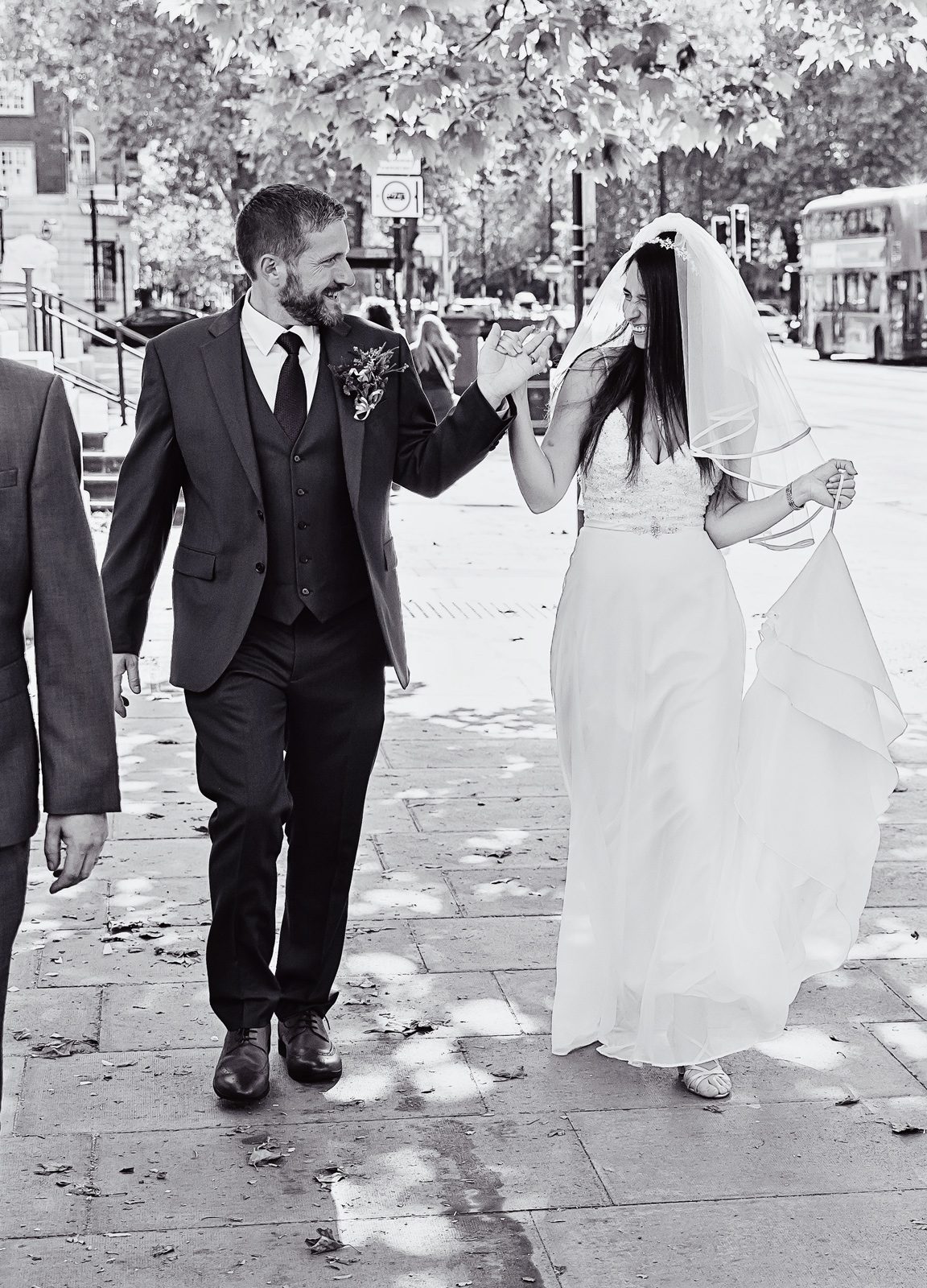 New bride and groom walk past Old Marylebone Town Hall after wedding