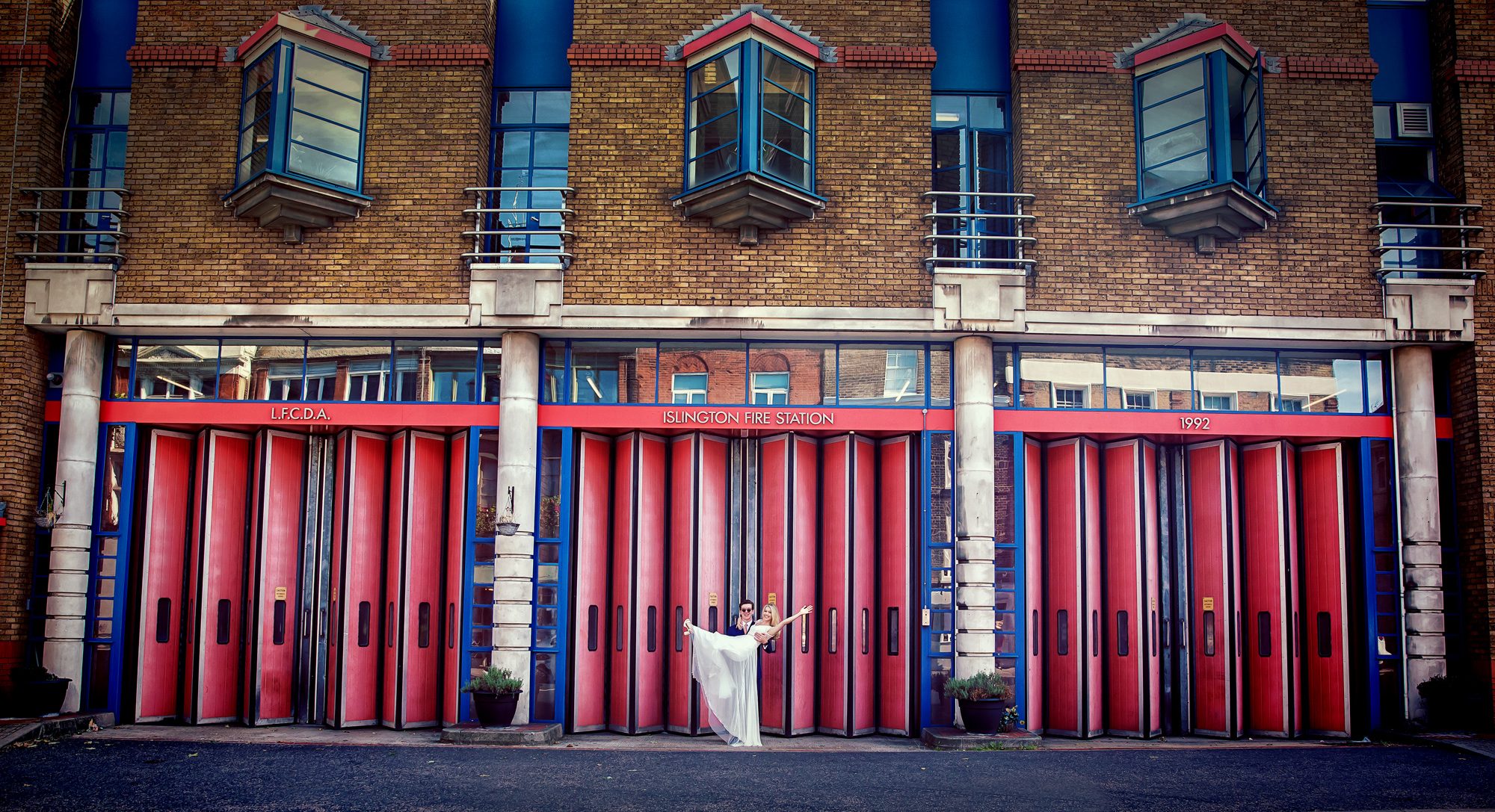 Bride and groom pose outside Islington Fire Station on wedding day