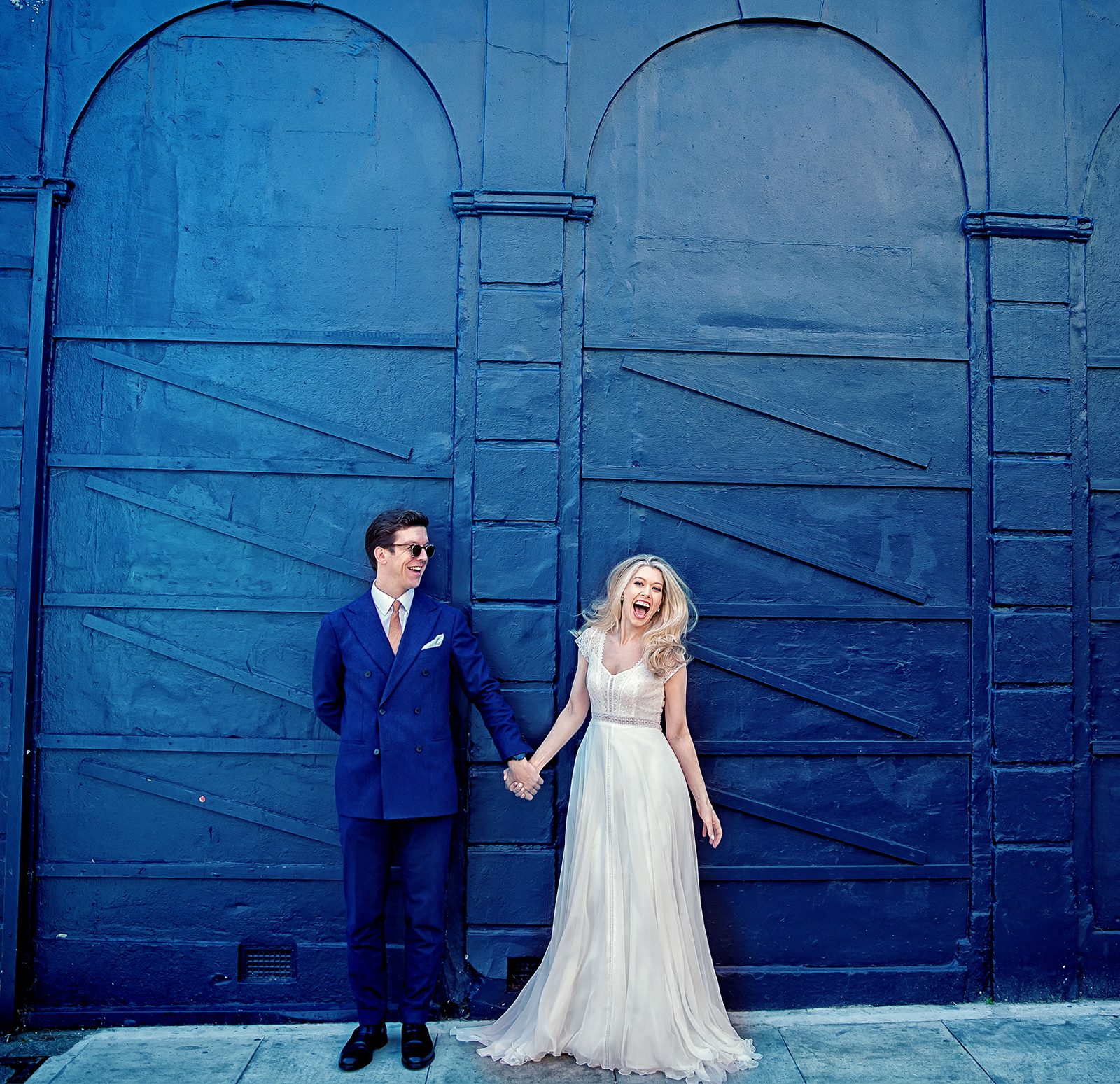 Islington Town Hall wedding couple pose by blue wall