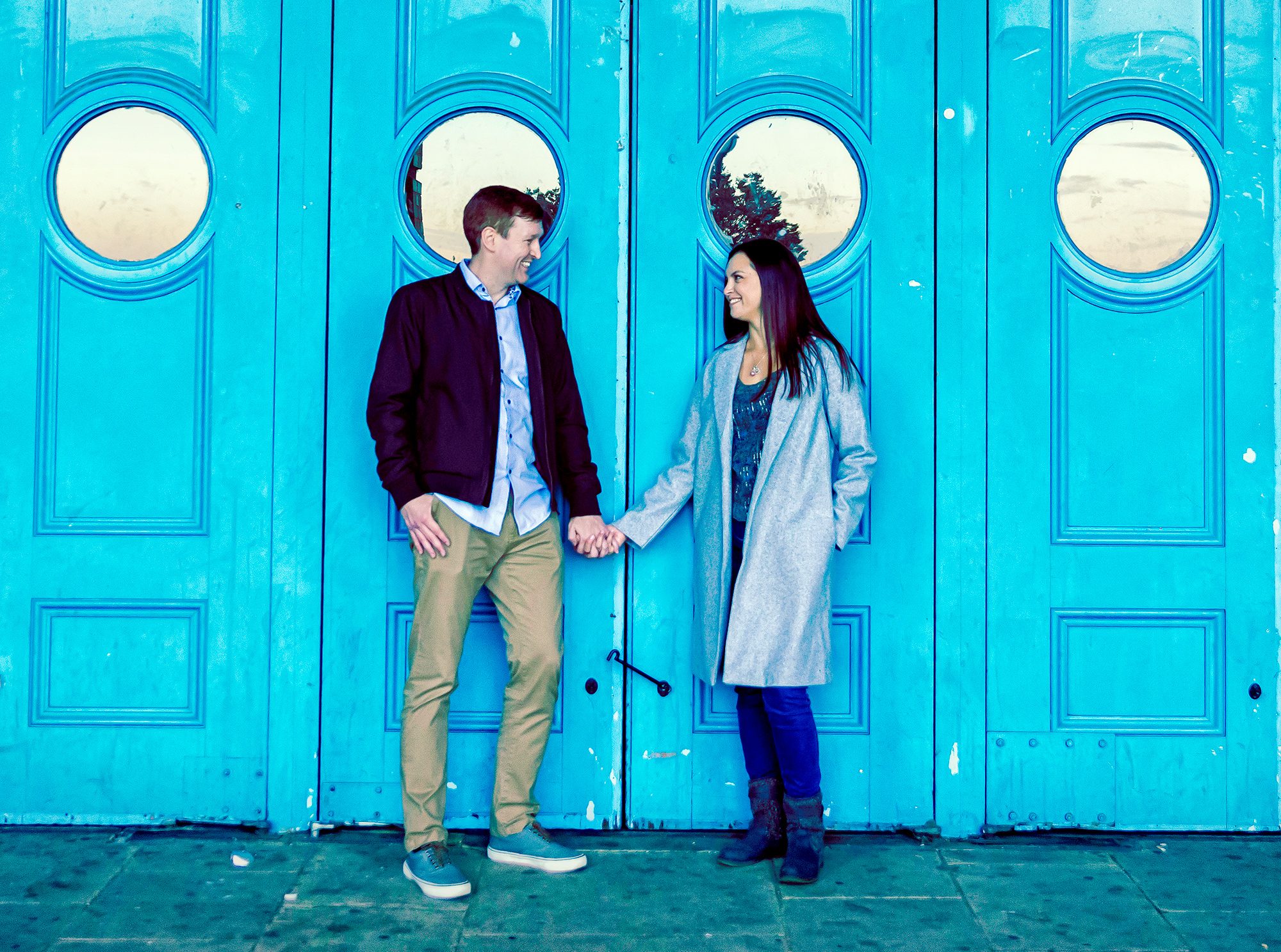 Engaged couple in front of blue doors Alexandra Palace