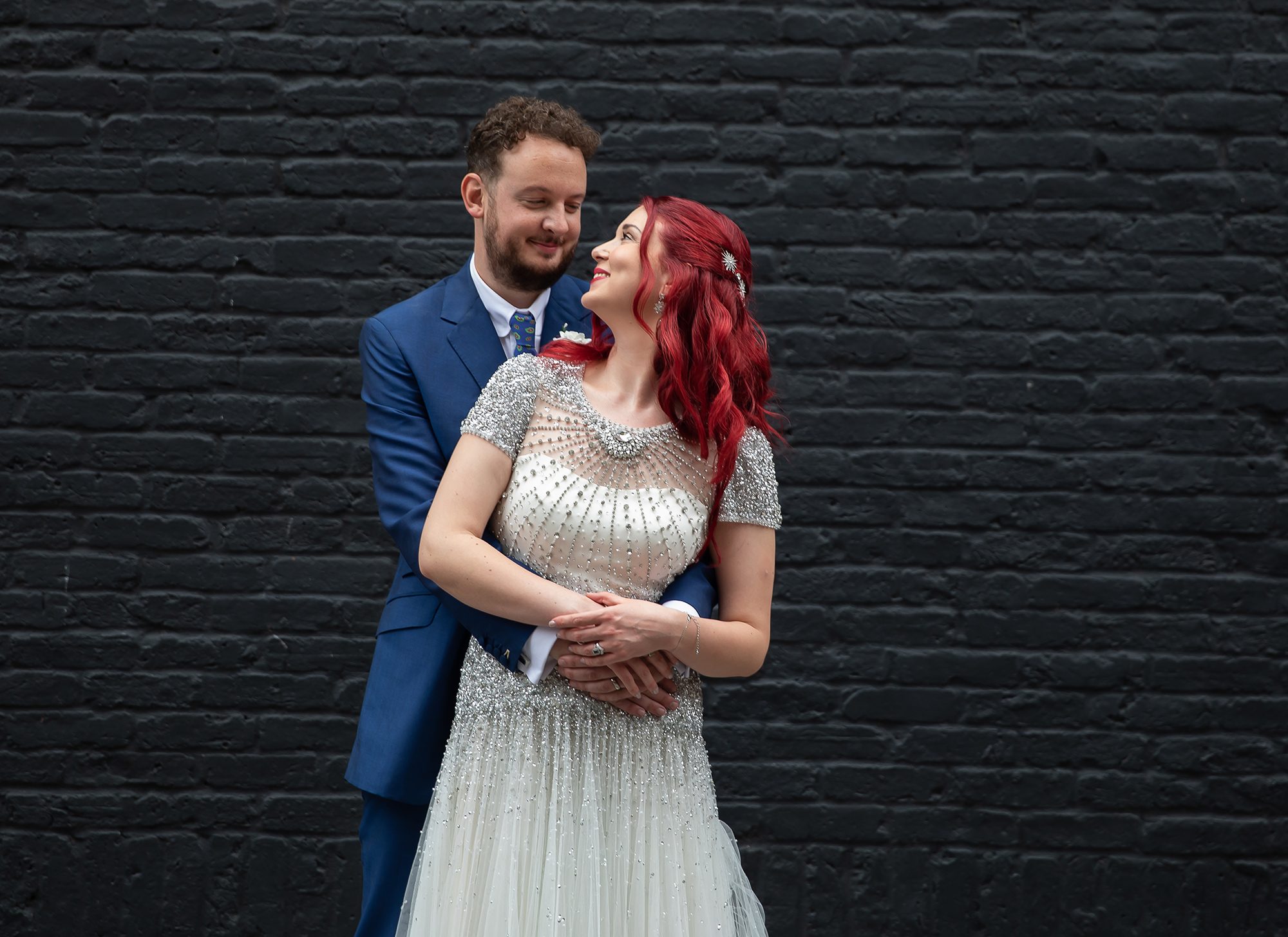 Bride and groom in front of black wall Islington wedding day