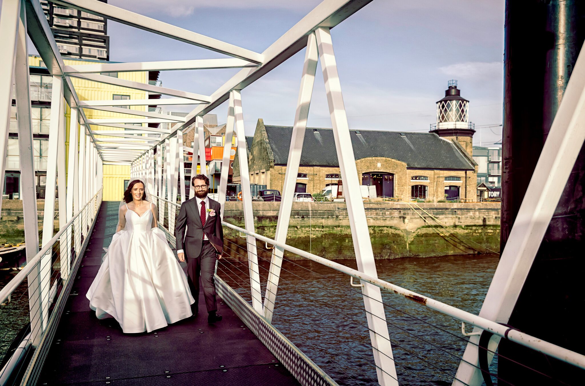 Bride and groom walk on pier at Trinity Buoy Wharf wedding day