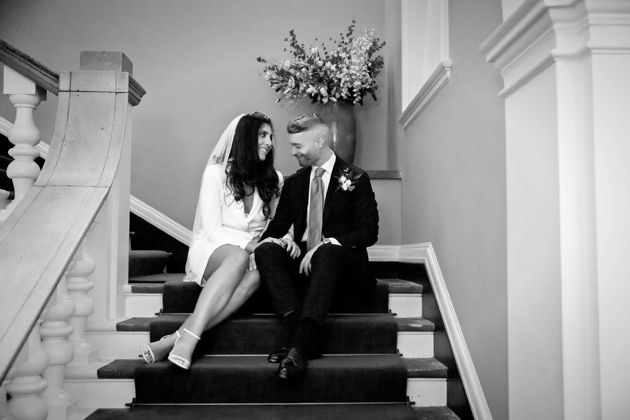 Bride and groom sat on stairs at Chelsea Old Town Hall wedding