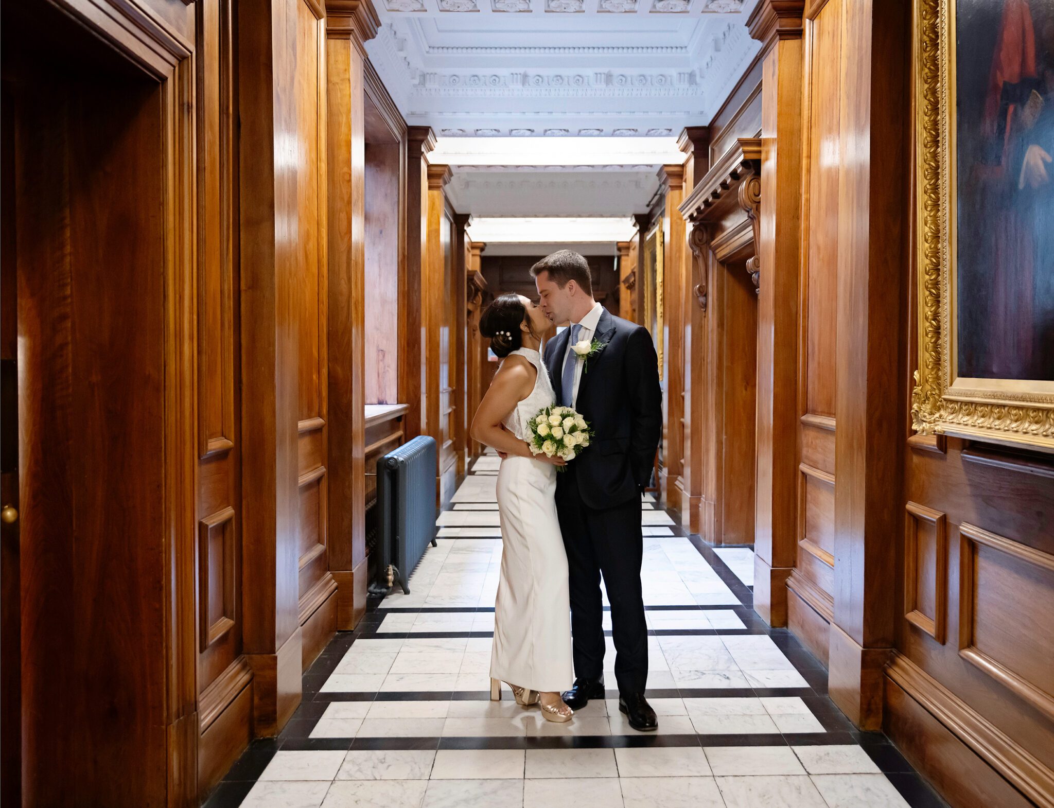 Couple kiss in corridor Old Marylebone Town Hall wedding