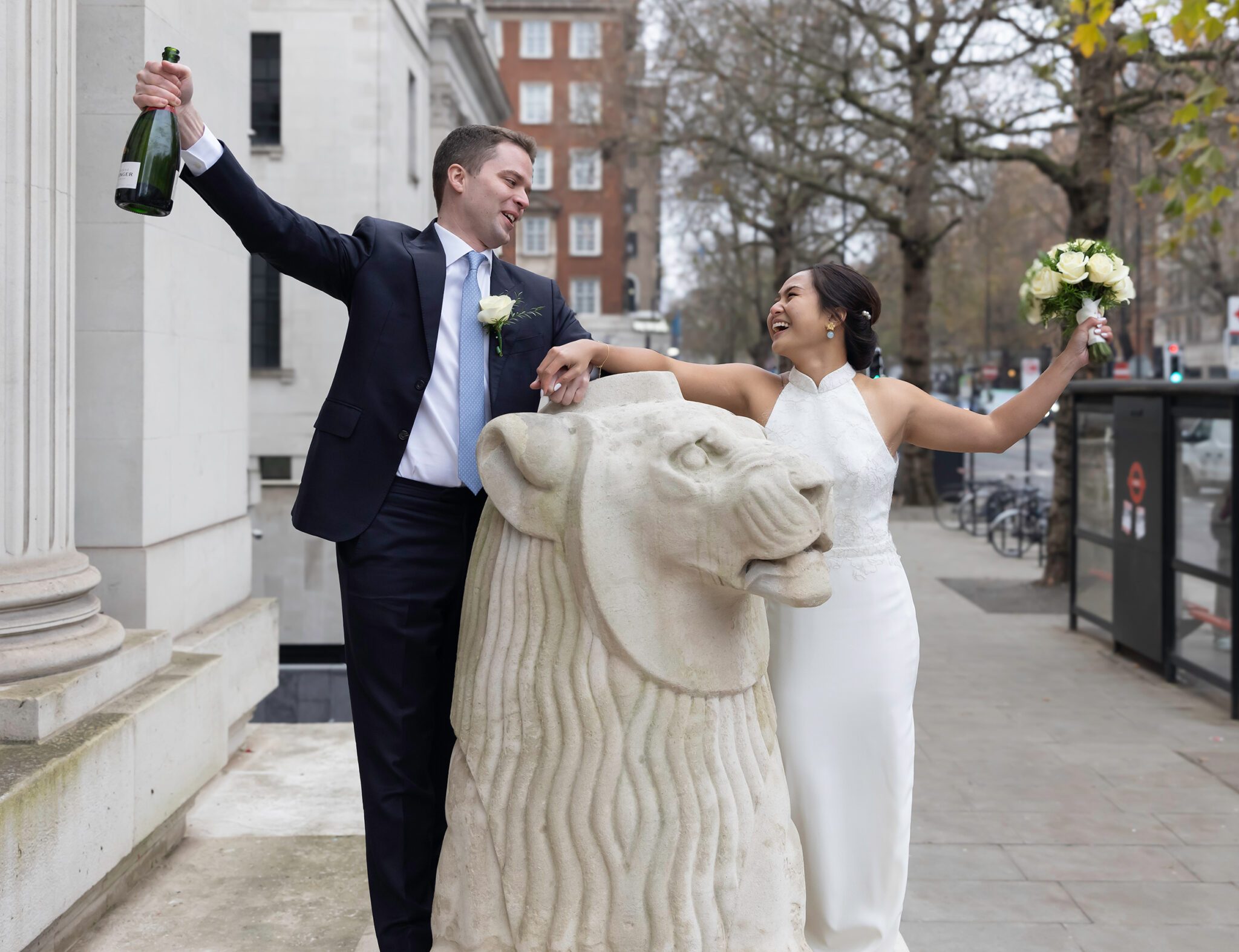 Wedding couple celebrate by lion outside Old Marylebone Town Hall